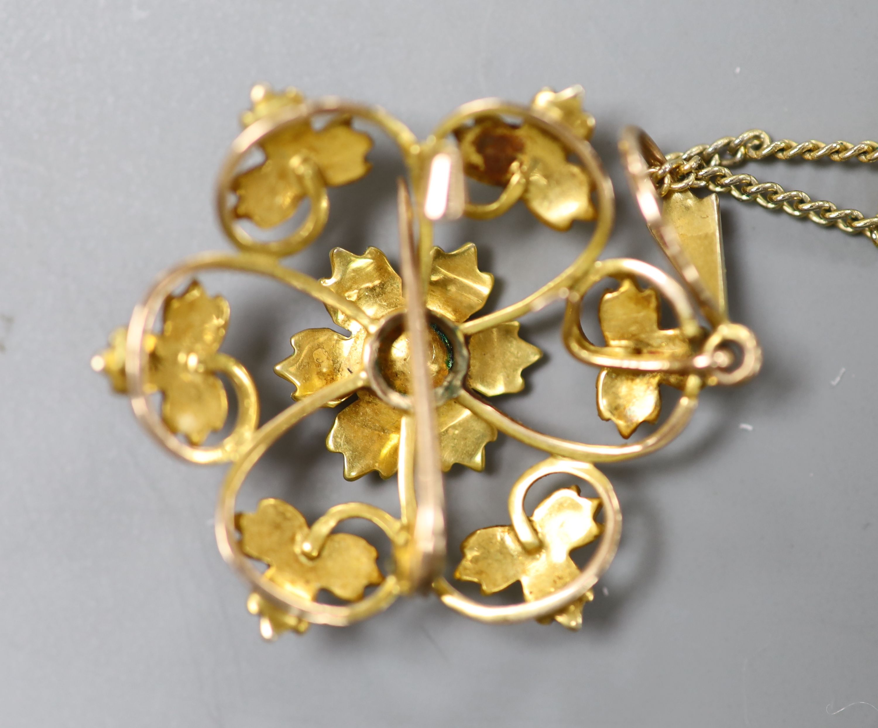 An Edwardian yellow metal and seed pearl set flower head pendant brooch